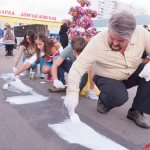 Активисты закрашивают рекламу спайсов.